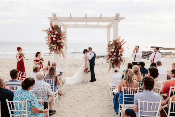 couple kissing on the beach at their destination wedding.